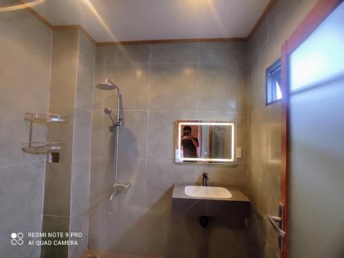 a bathroom with a sink and a shower and a mirror at Cat Tien Riverside Lodge in Tân Phú