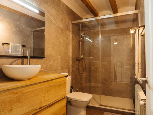 a bathroom with a toilet and a sink and a shower at Casa espaiosa amb llar de foc in Ribes de Freser