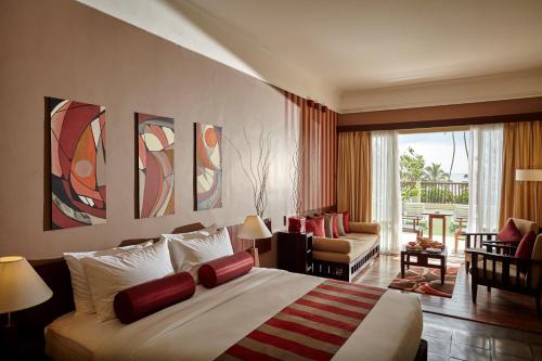 a bedroom with a large bed and a living room at Turyaa Kalutara in Kalutara