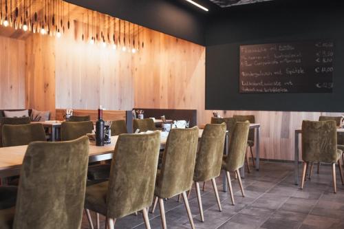 a dining room with tables and chairs and a chalkboard at Hotel Krone in Steinenbronn