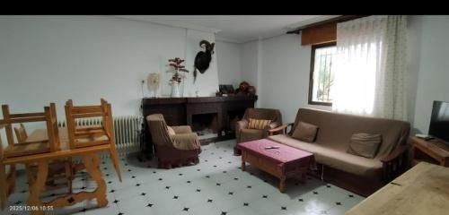 a living room with a couch and chairs and a fireplace at Refugio Ruta Río Borosa in Coto Ríos