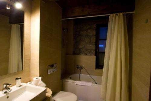 a bathroom with a sink and a toilet and a tub at Chalet Christantoni in Elati Trikalon