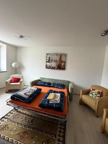 a bedroom with a bed and a couch and a chair at Casa Maddalena Lasino in Lasino