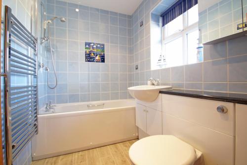 a bathroom with a toilet and a sink and a bath tub at Beudy'r March in Abersoch