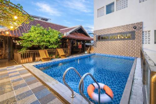 a swimming pool in front of a building at Mira Boutique Hotel Quy Nhon in Quy Nhon