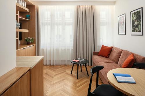 a living room with a couch and a table at Six Residences Prague in Prague