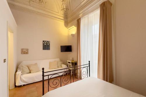 a bedroom with a bed in a room with a window at Antica Dimora Caruso in Catania