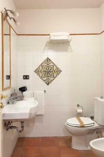 a white bathroom with a toilet and a sink at Antica Dimora Caruso in Catania