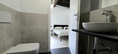 a bathroom with a sink and a toilet and a bedroom at Cinque Terre Homes by Bluchalet in Riomaggiore