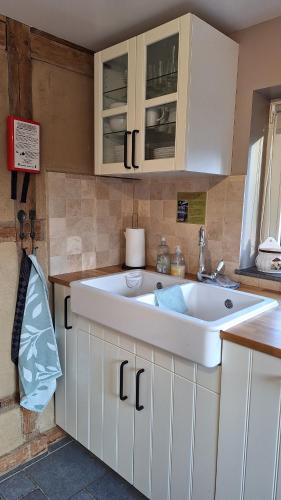 a kitchen with a large white sink at Le Clos du Cerf - Le Sous-bois in Stoumont