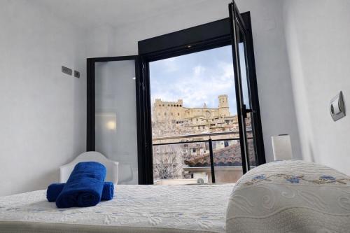 a bedroom with a blue stuffed animal on a bed with a window at Apartamentos La Aubaga in Valderrobres