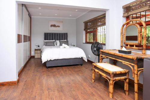 a bedroom with a bed and a dressing table at African Oasis Kenya in Somerset West
