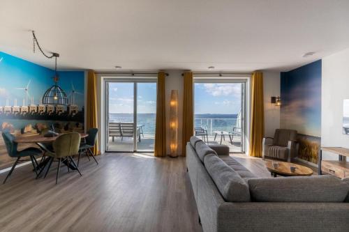 a living room with a couch and a table at Welcome in - Royaal appartement 'De Zeester' met riant terras I Gorishoeksedijk 41, Scherpenisse in Scherpenisse