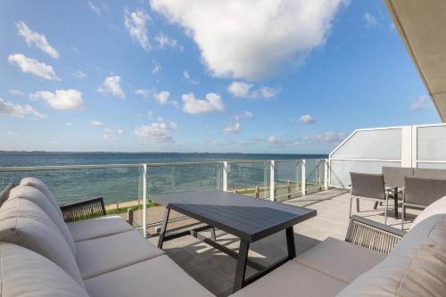 a balcony with a table and a view of the ocean at Welcome in - Royaal appartement 'De Zeester' met riant terras I Gorishoeksedijk 41, Scherpenisse in Scherpenisse