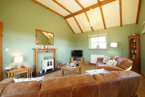 a living room with a couch and a table at Beudy'r March in Abersoch