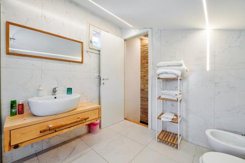 a white bathroom with a sink and a mirror at Torretta In Centro Perugia in Perugia