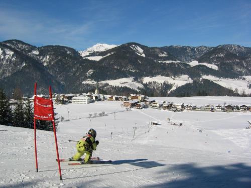 a person on skis in the snow next to a red flag at Hotel Neuwirt in Brandenberg