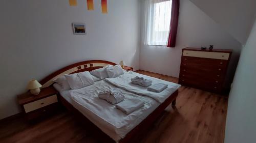 a bedroom with a bed with towels on it at Batthyány Villapark in Zalacsány