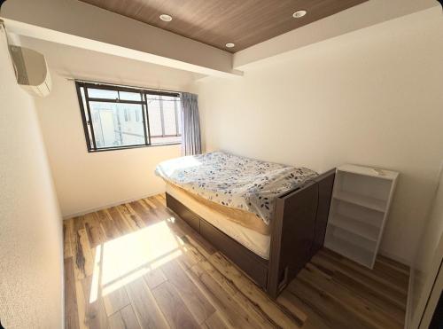 a small bedroom with a bed and a window at コージー久が原トイレお風呂共用鍵付き個室 in Tokyo