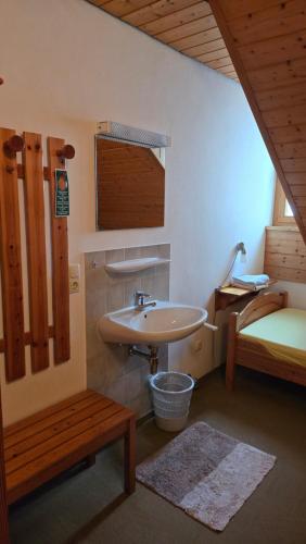 a bathroom with a sink and a bed at PensionSchilling in Grasbrunn