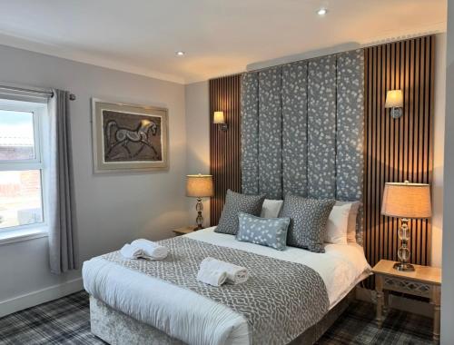 ein Schlafzimmer mit einem Bett, auf dem zwei Handtücher liegen in der Unterkunft Belstane Manor in Carluke