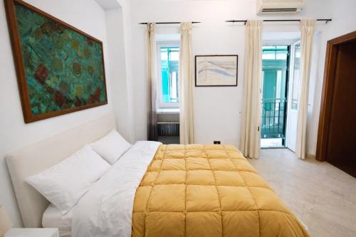 a bedroom with a bed with a yellow blanket at A due passi dal Teatro Massimo in Palermo