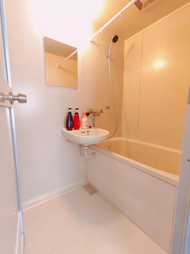 a bathroom with a sink and a bath tub at DiDi Calm 105 in Tokushima