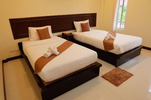 a bedroom with two beds with stuffed animals on them at Baan Por Pla Resort in Prachuap Khiri Khan