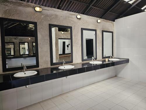 a public bathroom with four sinks and mirrors at The Rock Lodge in Ban Nahin-Nai (1)