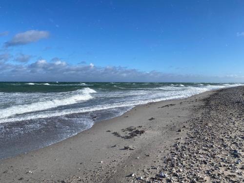 a beach with the ocean and waves at Bauernhuus 6 in Fehmarn