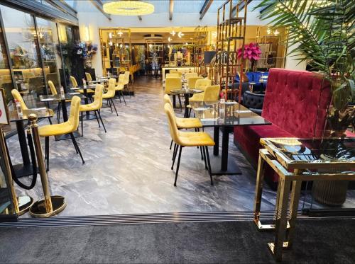 a restaurant with tables and chairs and a red couch at Boutique Hotel am Bodensee in Friedrichshafen