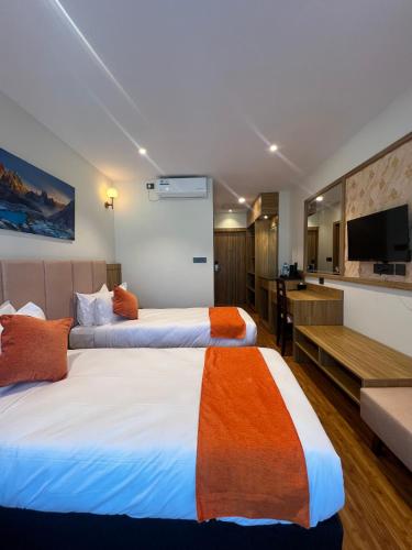 a hotel room with two beds and a television at Hotel Eleven in Kathmandu