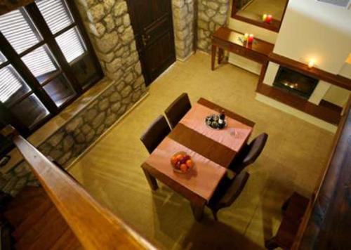 a dining room with a table and chairs and a fireplace at Chalet Christantoni in Elati