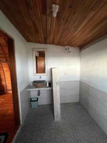 a bathroom with a sink and a wooden ceiling at Ayolah surf House and Surfcamp in Jembrana