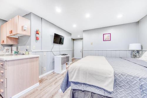 a bedroom with a large bed and a flat screen tv at Sea Treasures Inn Unit #212 in Rockaway Beach