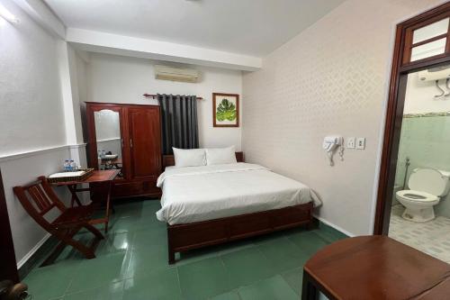 a bedroom with a bed and a desk and a toilet at Thao Trang Hotel in Dong Hoi