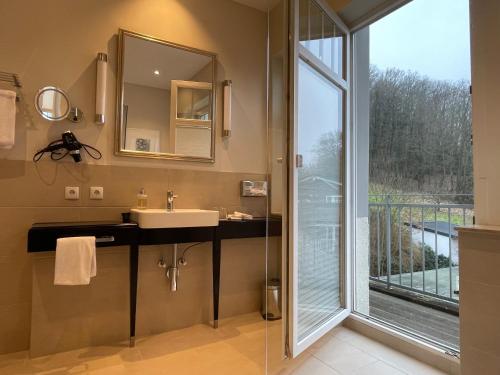 a bathroom with a sink and a glass shower at Villa Waldfrieden - Design trifft Budget in Annweiler am Trifels