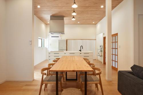 a kitchen with a wooden table and chairs in a room at 修善寺あざみ Luxury Japanese Villa with Mt Fuji Views and Onsen in Izu