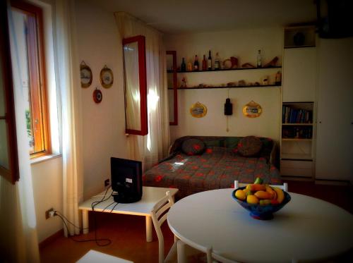 ラ・マッダレーナにあるAppartamento La Maddalenaのベッド1台、テーブル(フルーツボウル付)が備わる客室です。