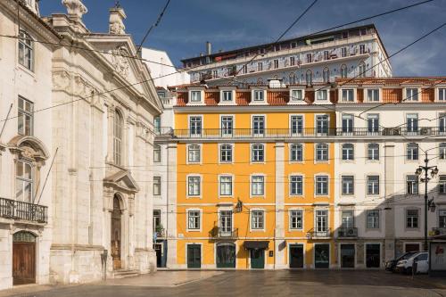 a yellow building in front of a large building at Ando Living - Corpo Santo House in Lisbon