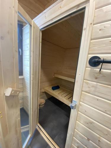 a small wooden sauna with a door open at Bosnest Nr 176 in Frankenau