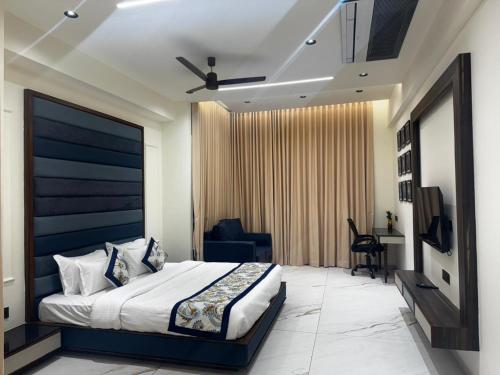 a bedroom with a king sized bed and a desk at Lords Swastik Studio Kodinar in Kodīnar