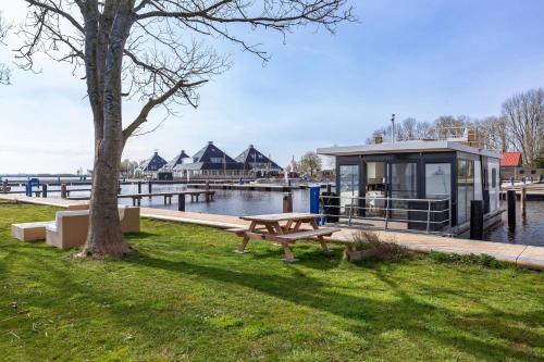 a building with a picnic table next to the water at Welcome in - Houseboat Agua Dolce met tuin, Paviljoenwei 4, Sneek - Offingawier in Offingawier