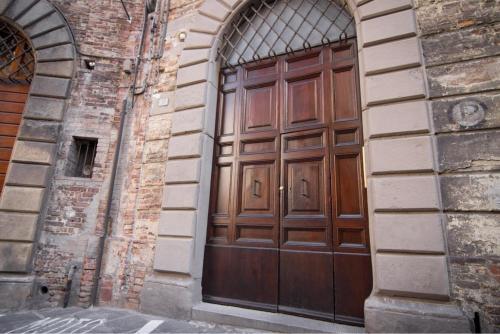 a large wooden door on the side of a building at Rinidia Siena Centro in Siena