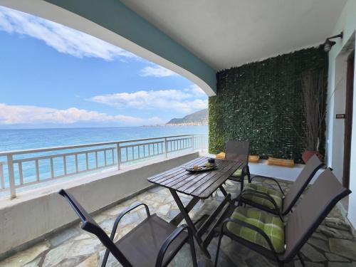 a table and chairs on a balcony overlooking the ocean at Beachfront summer house in Derveni