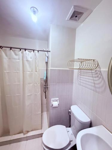 a white bathroom with a toilet and a shower at Compact Studio Unit At Mesaverte Residences in Pontud