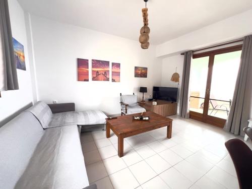 a living room with a couch and a table at Beachfront summer house in Derveni