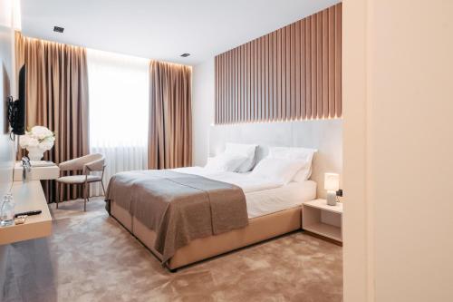 a bedroom with a bed and a desk and a chair at Hotel Restaurant Kod Barića in Grude