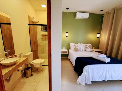 a hotel room with a bed and a bathroom at Ypê Hospedagem II in Sao Jorge