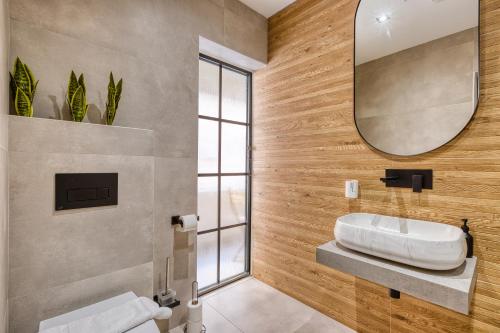 a bathroom with a sink and a mirror at Stylish 1-Bedroom Apartment Just 5 Minutes from Valletta by Ferry in Mosta